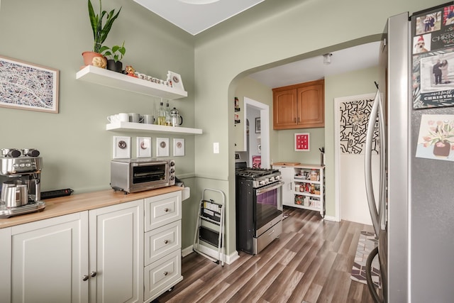 1343 Northway St, Ferndale, MI 48220 - kitchen featuring light countertops, stainless steel appliances, arched walkways, and dark wood finished floors