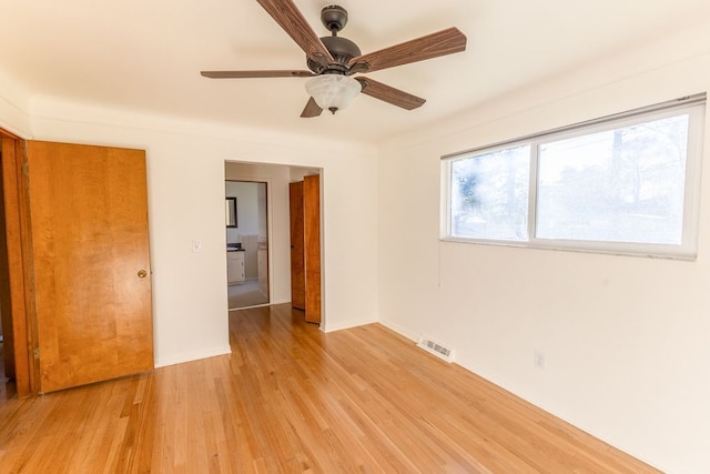 spare room featuring ceiling fan, visible vents, baseboards, and light wood-type flooring