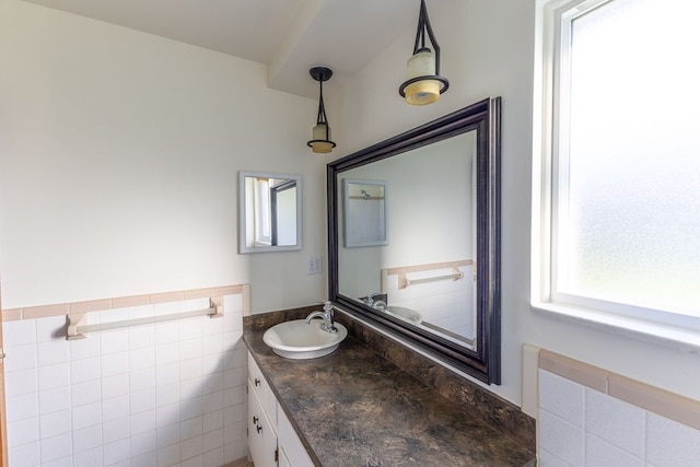 bathroom featuring tile walls, wainscoting, and vanity