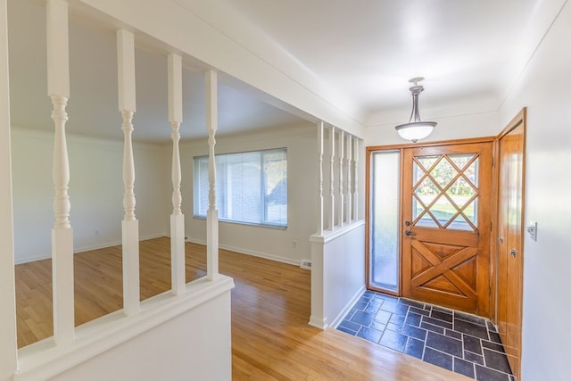entrance foyer featuring baseboards, a wealth of natural light, and wood finished floors