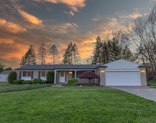 view of front of home featuring brick siding, a garage, a front yard, and concrete driveway