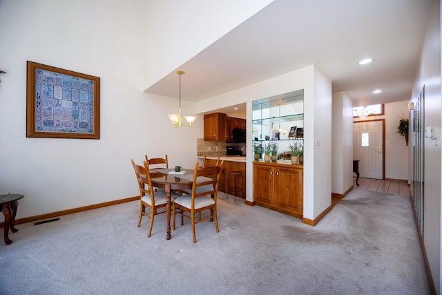 dining room with baseboards, light colored carpet, recessed lighting, and a chandelier