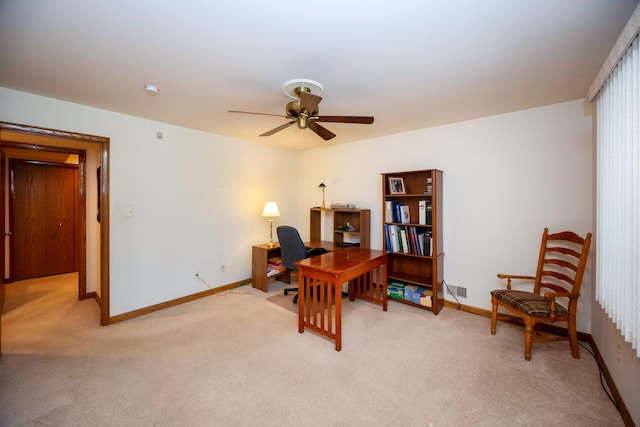 office with a ceiling fan, baseboards, and light colored carpet