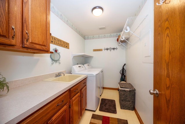 laundry room featuring a sink, light floors, washing machine and dryer, and cabinet space