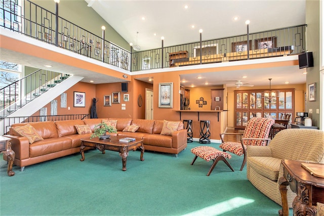 living room with ceiling fan, stairs, a high ceiling, carpet, and recessed lighting