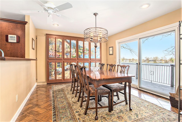 dining space with baseboards, ceiling fan with notable chandelier, and recessed lighting