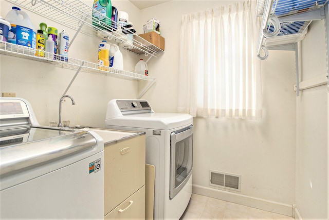 laundry room with laundry area, visible vents, light tile patterned floors, baseboards, and washer and dryer
