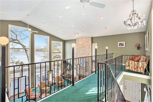 corridor with a chandelier, carpet, an upstairs landing, a water view, and vaulted ceiling