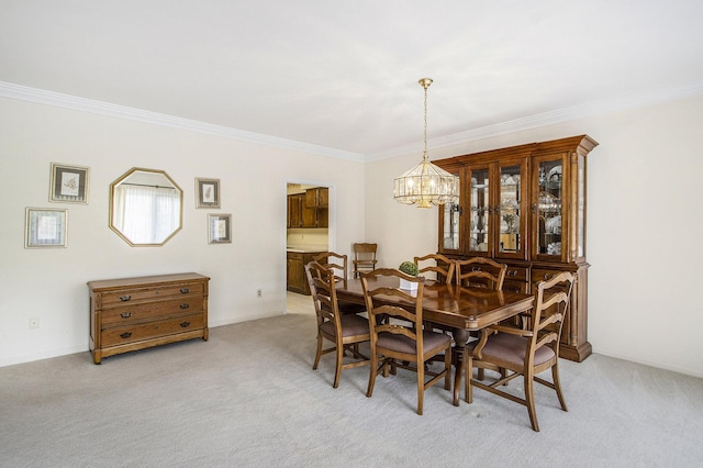 dining space with an inviting chandelier, ornamental molding, and light colored carpet