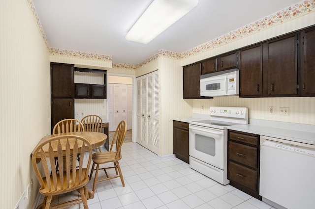 kitchen with light countertops, dark brown cabinetry, white appliances, and wallpapered walls