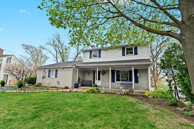 traditional-style house with covered porch, brick siding, and a front yard
