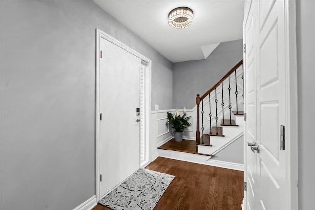 foyer entrance featuring stairs, baseboards, and wood finished floors