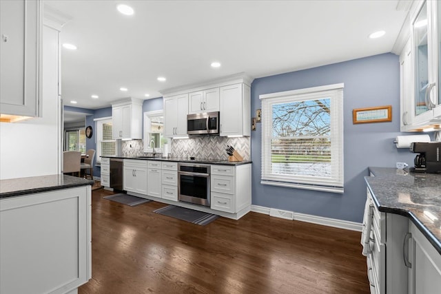 kitchen featuring visible vents, decorative backsplash, a sink, dark wood finished floors, and stainless steel appliances