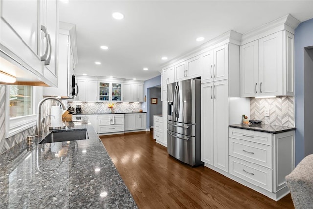 kitchen featuring backsplash, white cabinetry, a sink, and stainless steel fridge with ice dispenser