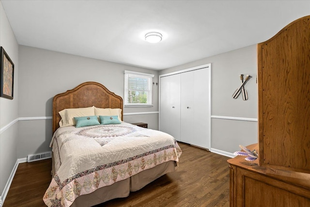 bedroom featuring baseboards, a closet, dark wood-style flooring, and visible vents