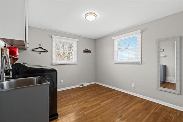 laundry area with visible vents, cabinet space, baseboards, and a healthy amount of sunlight