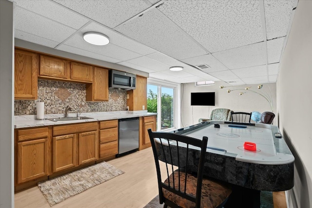 interior space featuring brown cabinets, decorative backsplash, a sink, and light countertops