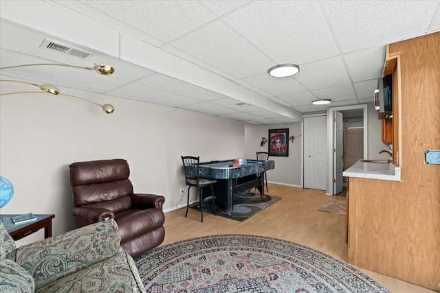 interior space featuring visible vents, a sink, light wood-style flooring, and a paneled ceiling