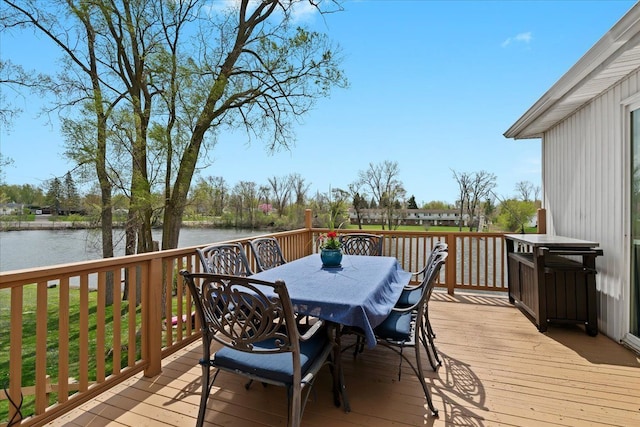 wooden terrace with a water view and outdoor dining area