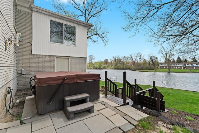 view of patio featuring a water view and a hot tub