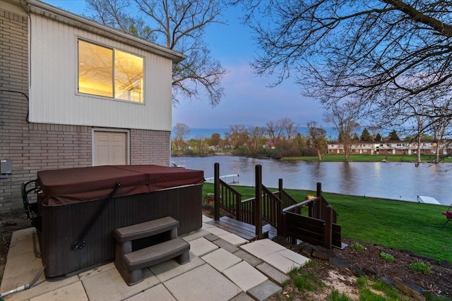 view of patio featuring a water view and a hot tub