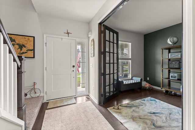 entryway featuring stairs, baseboards, and wood finished floors
