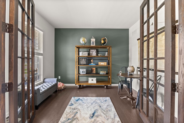 living area featuring baseboards, french doors, and wood finished floors