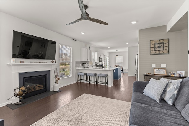 living area with recessed lighting, a ceiling fan, and dark wood-style floors