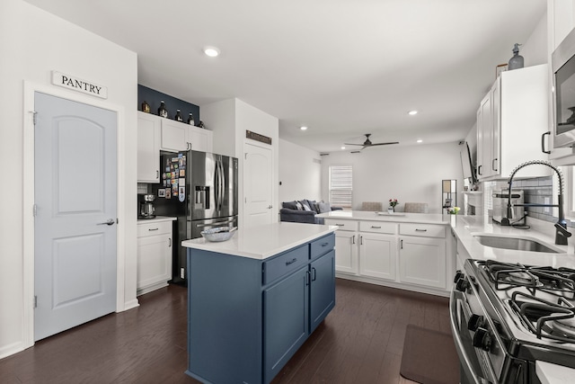 kitchen featuring a sink, ceiling fan, blue cabinets, and white cabinets
