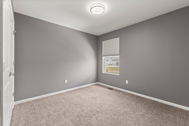 carpeted spare room with baseboards and visible vents