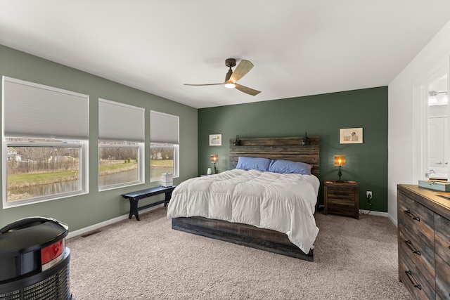 carpeted bedroom featuring visible vents, baseboards, and ceiling fan