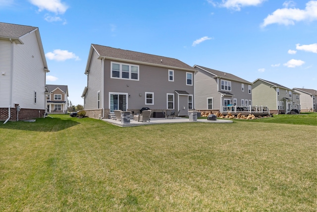 back of property featuring a yard, a residential view, and a patio area