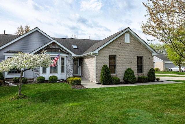 single story home featuring roof with shingles, stone siding, brick siding, and a front yard
