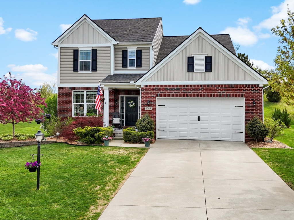 2245 Kenan Dr, Wixom, MI 48393 - traditional home featuring a shingled roof, board and batten siding, and a front lawn