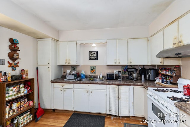 kitchen featuring a sink, white cabinetry, under cabinet range hood, white gas range oven, and light wood finished floors