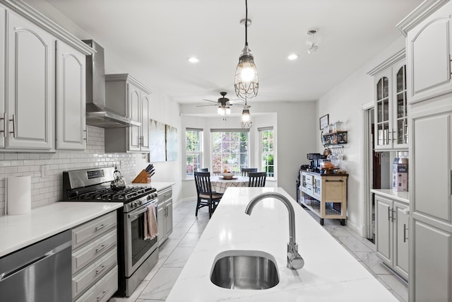 7891 Robindale Ave, Dearborn Heights, MI 48127 - kitchen featuring appliances with stainless steel finishes, wall chimney range hood, recessed lighting, a ceiling fan, and a sink