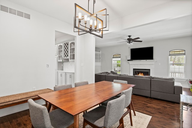 7891 Robindale Ave, Dearborn Heights, MI 48127 - dining space featuring a warm lit fireplace, healthy amount of natural light, dark wood finished floors, and a ceiling fan