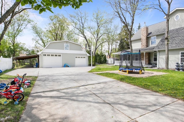 7891 Robindale Ave, Dearborn Heights, MI 48127 - view of yard with a trampoline, an outdoor structure, a garage, and driveway
