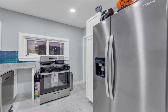 kitchen featuring white cabinets, light stone counters, marble finish floor, stainless steel appliances, and recessed lighting