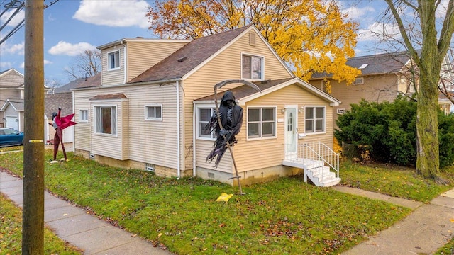 view of side of home with a lawn and roof with shingles
