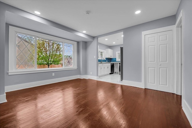 3690 Phillips Ave, Berkley, MI 48072 - unfurnished living room featuring a sink, baseboards, recessed lighting, and light wood-style flooring