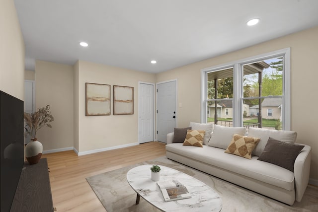 living area with recessed lighting, baseboards, and light wood finished floors