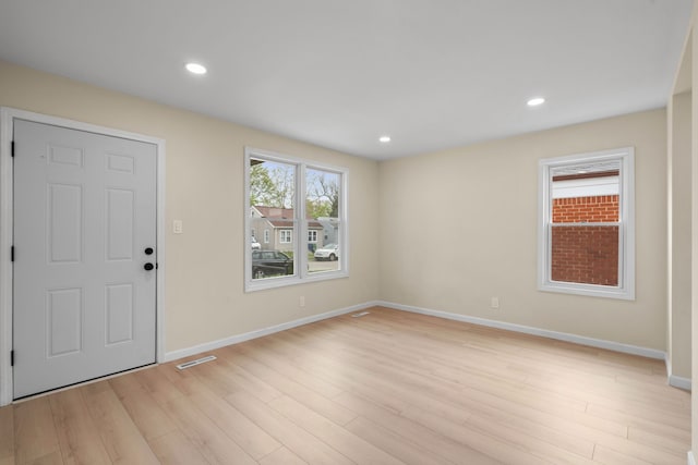 entryway with baseboards, light wood finished floors, and visible vents