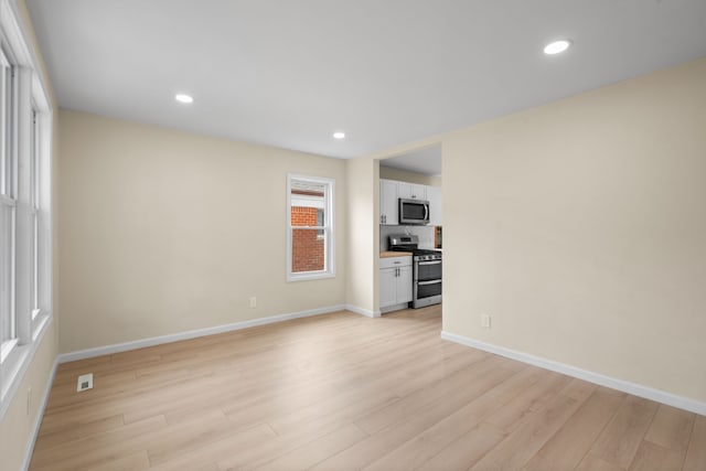 unfurnished living room with light wood-style floors, baseboards, and recessed lighting