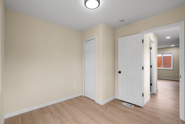 unfurnished bedroom with baseboards, visible vents, and light wood-style floors