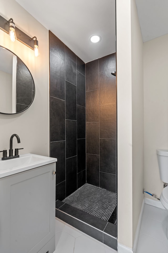 full bath with vanity, tile patterned flooring, a tile shower, and toilet