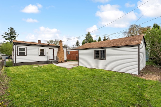 rear view of property with fence, a chimney, an outbuilding, entry steps, and a yard