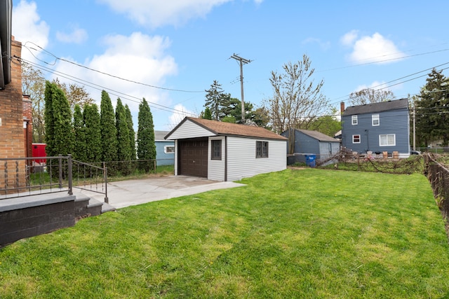 view of yard featuring a garage, fence, and an outdoor structure