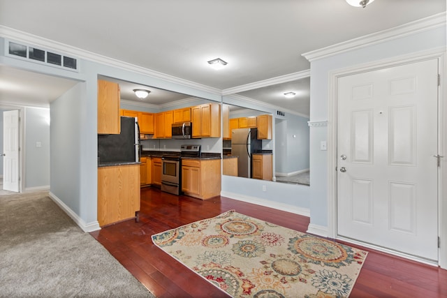 kitchen with crown molding, stainless steel appliances, dark wood finished floors, and visible vents