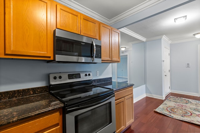 kitchen with crown molding, stainless steel appliances, dark stone counters, and dark wood-style flooring